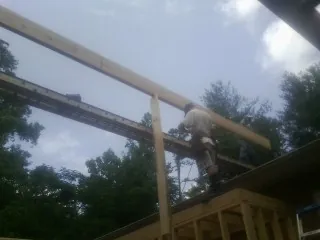 Carpenter setting a ridge beam over a new addition frame — Ice Dam Removal by Roofing Brothers in Lake Orion