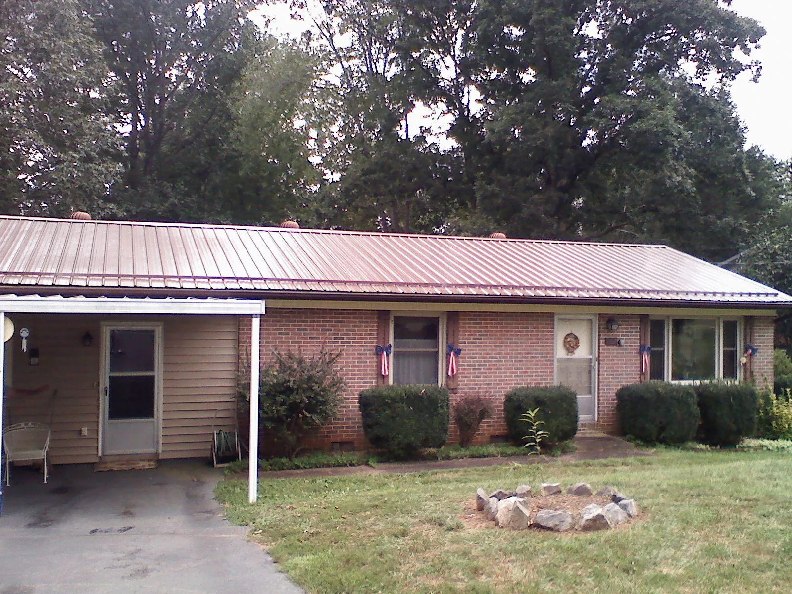 Bronze metal roof and carport on a brick ranch home — Roof Repair work by our crew in Lake Orion