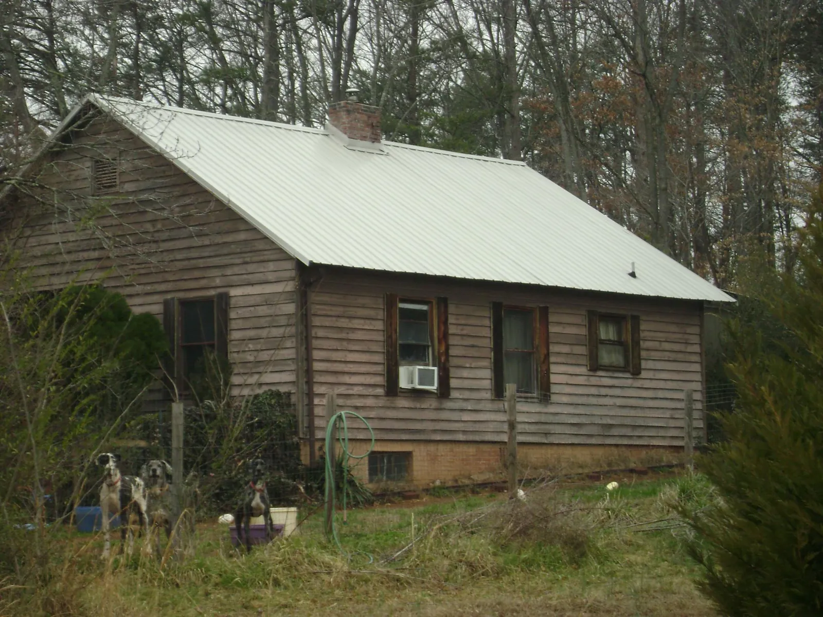 White metal roof on an old wood sided farmhouse, from a Metal Roof Installation job in Lake Orion